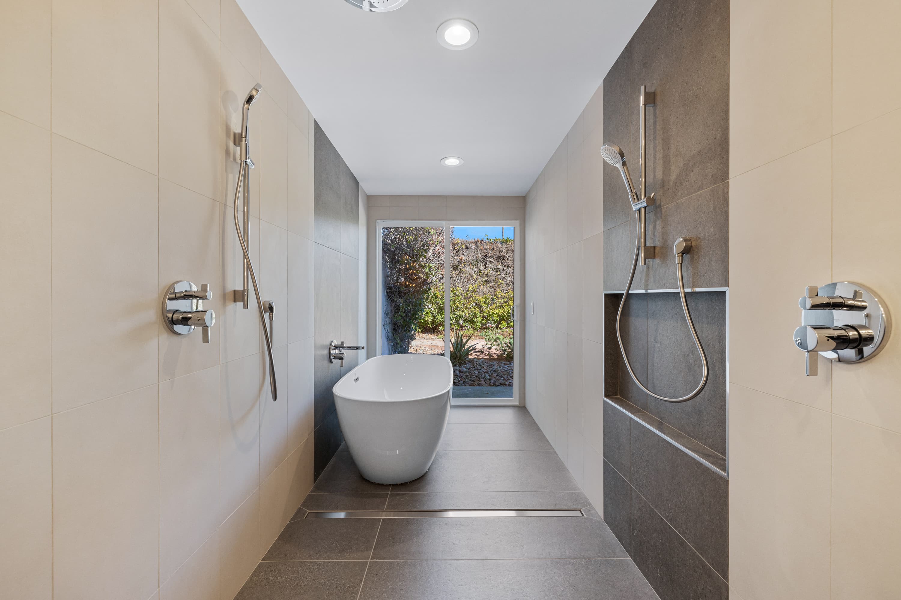 Freestanding tub between double showers