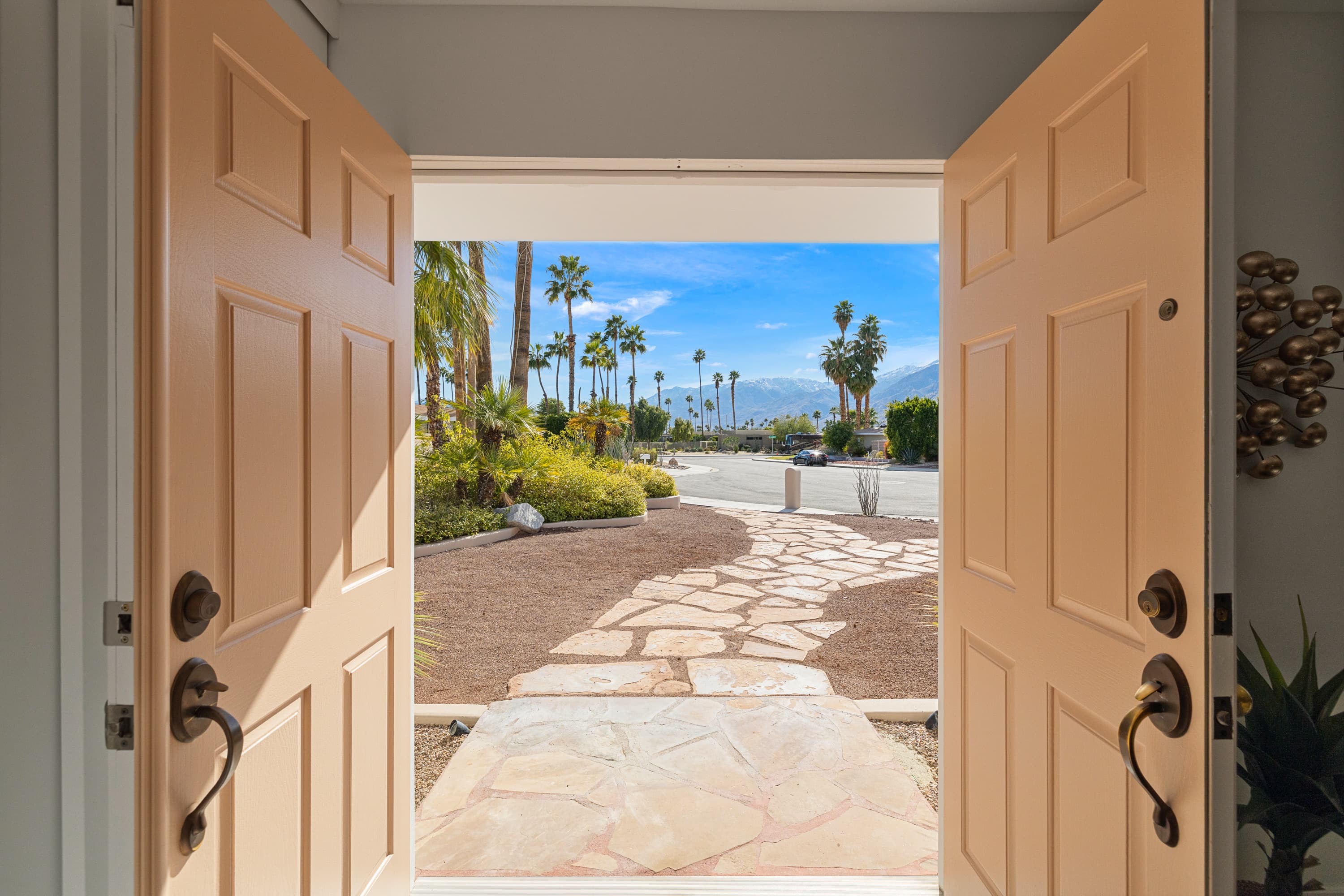Front doors framing the flagstone path and snow-capped mountains