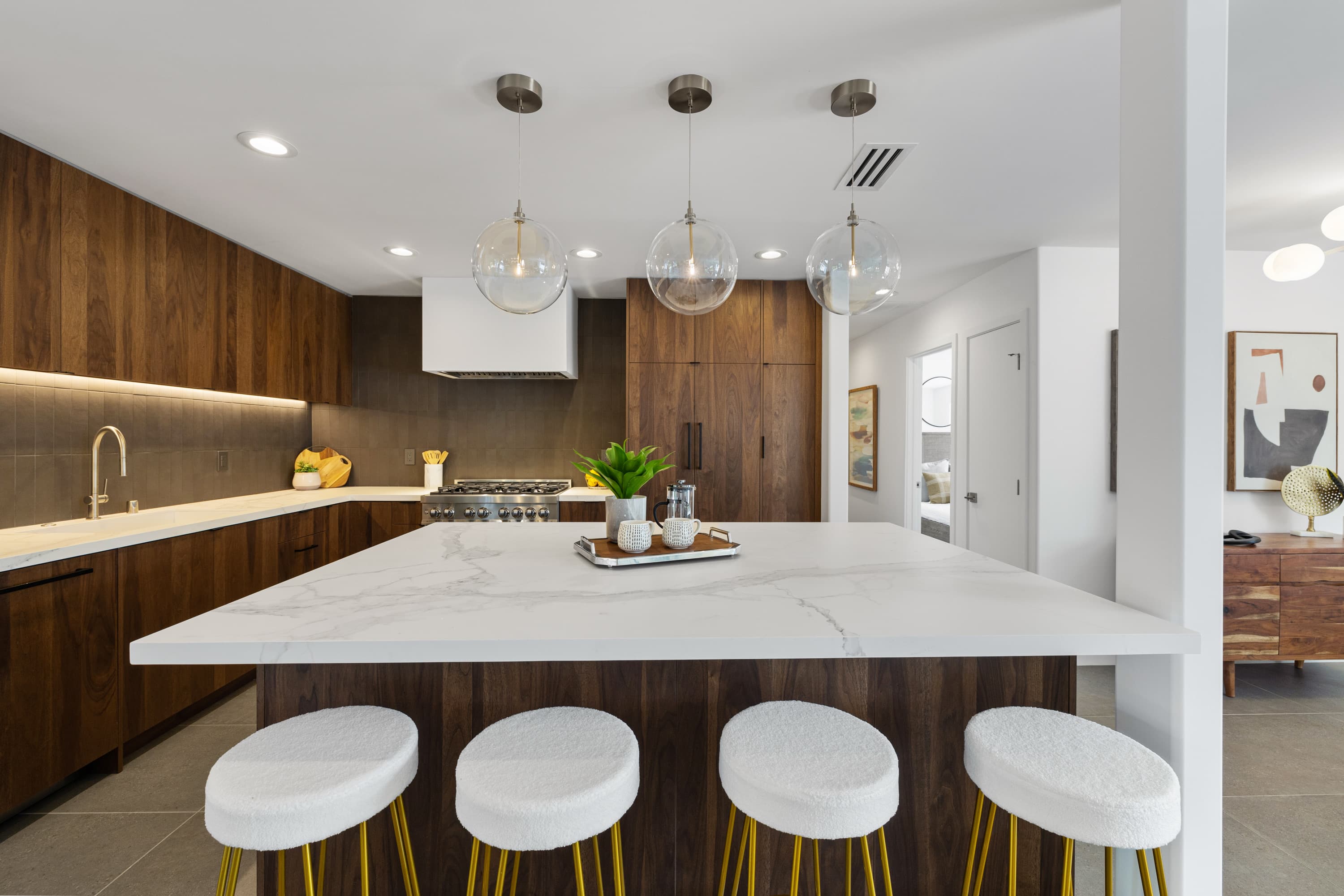 Walnut chef's kitchen with porcelain-topped island and brass pendants