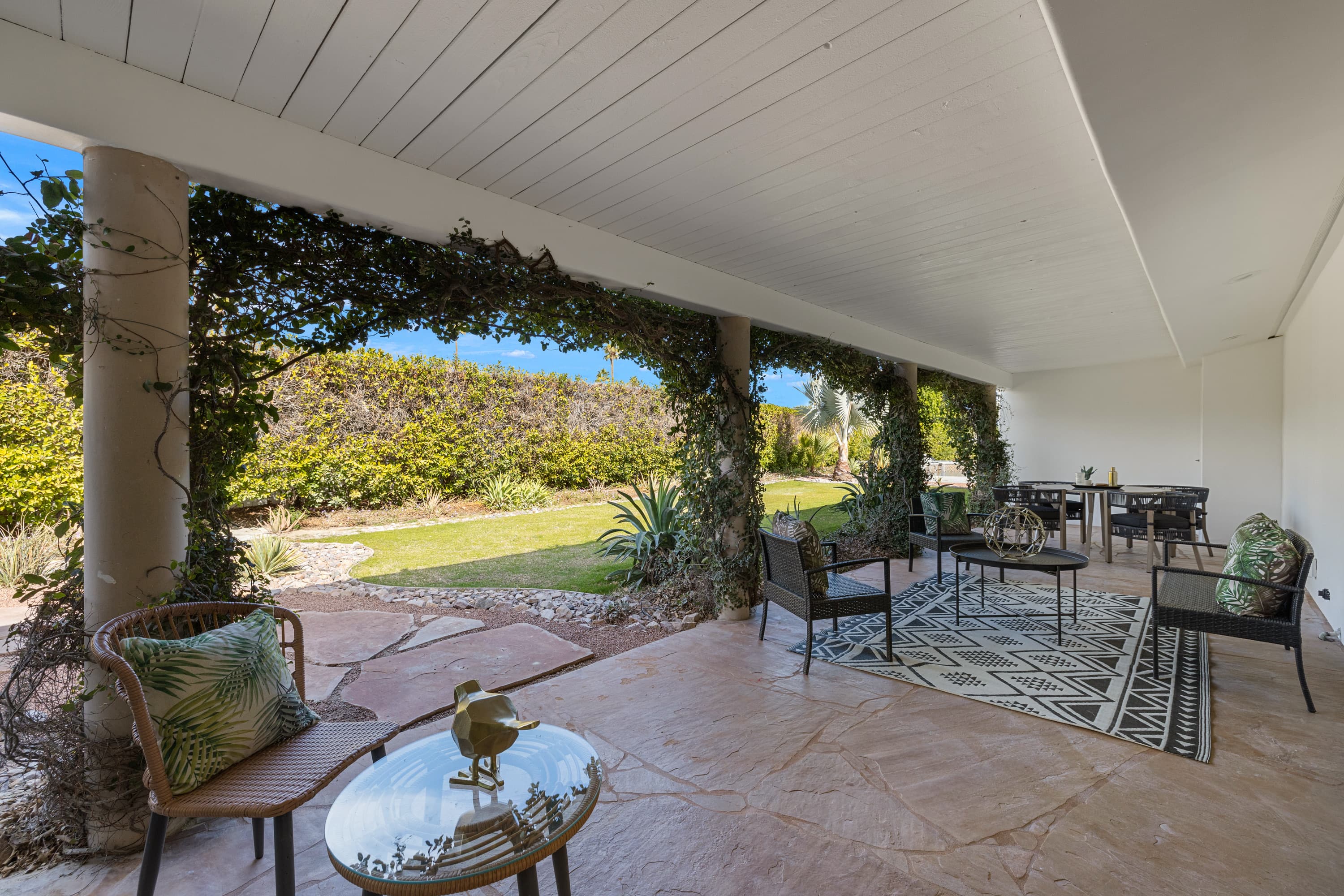 Covered veranda with ivy-wrapped columns overlooking the lawn